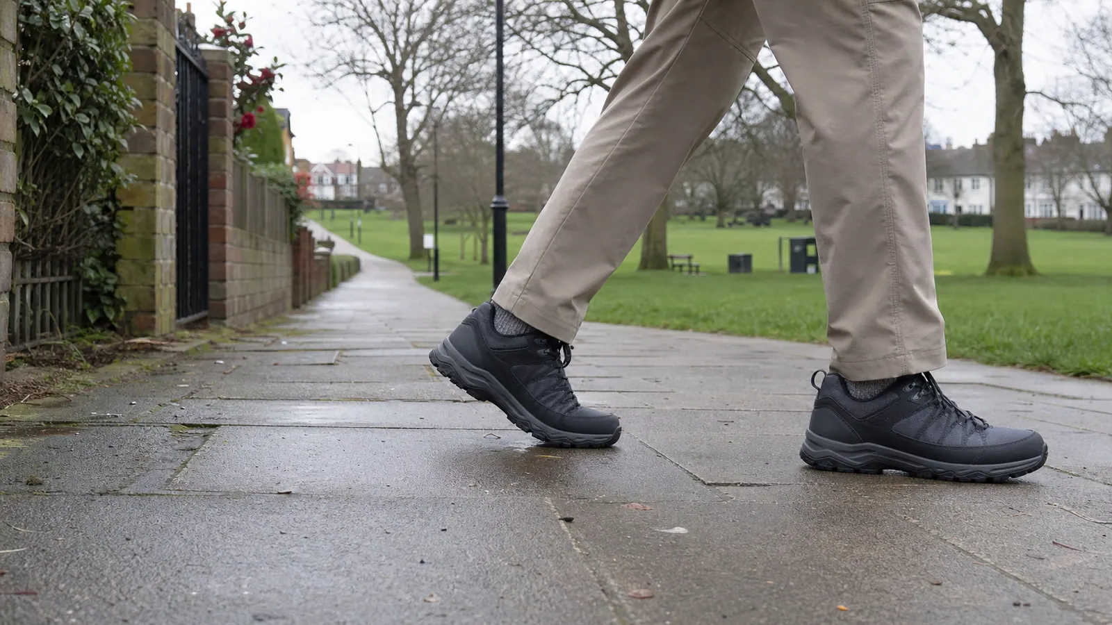 Unbranded walking shoes on a damp pavement beside a park