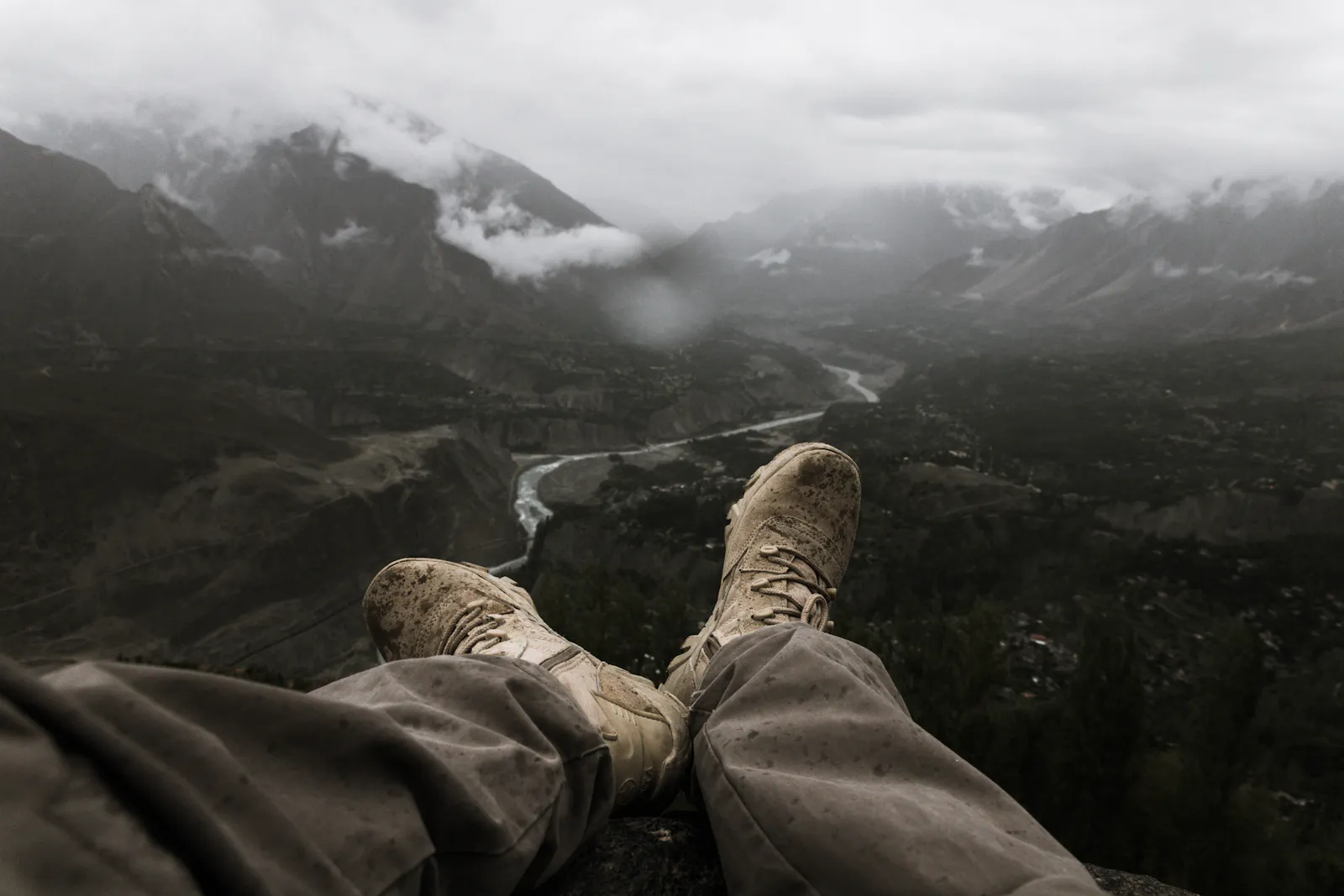 Mud-stained hiking boots overlooking a misty valley